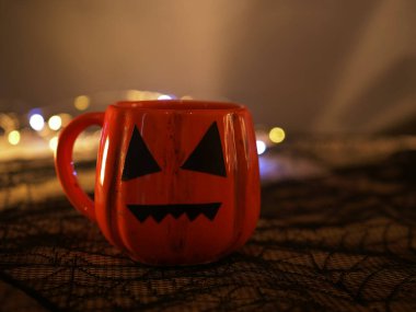 Cadılar Bayramı balkabağı içeceği, krema kaplı koyu arkaplan 