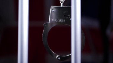 Kelepçeler hapishane parmaklıklarında sallanır. 