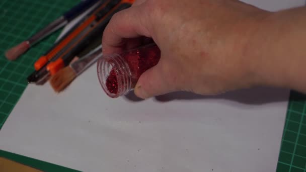 Hand mit rotem Glitzer und Bastelmaterial für Kunstprojekte — Stockvideo