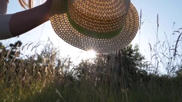 Femme tient chapeau de paille devant le soleil d'été — Video