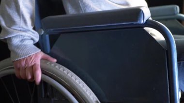 Tekerlekli sandalye kullanıcısı elleri sandalyeyi iterken