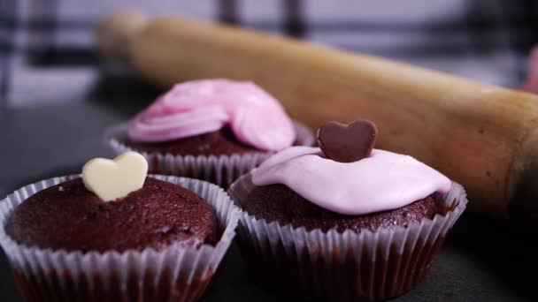 Kremayla süslenmiş çikolatalı kekler ve çikolatalı aşk kalpleri. — Stok video
