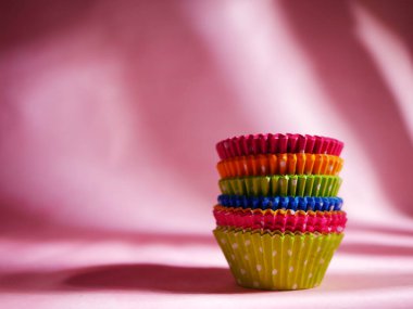 Pembe arka planda pişirmek için farklı renklerde Bun kutuları 