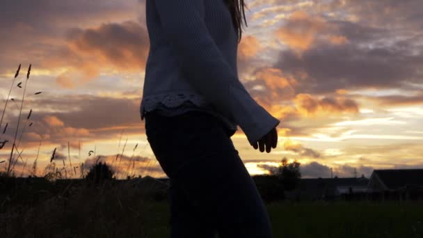 Donna silhouette si gira a guardare il tramonto d'oro — Video Stock