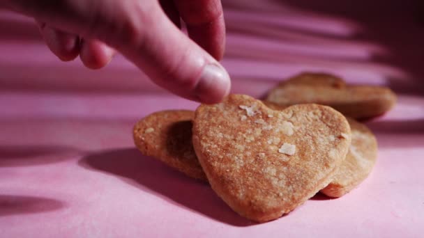 Eszik szív alakú friss sütemény rózsaszín háttér — Stock videók