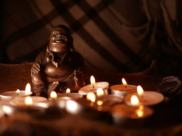 Statua di Buddha meditazione con candele luce del tè colpo medio — Foto Stock