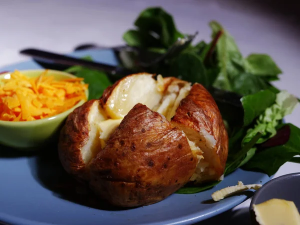 Baked jacket potato with cheese and salad sides