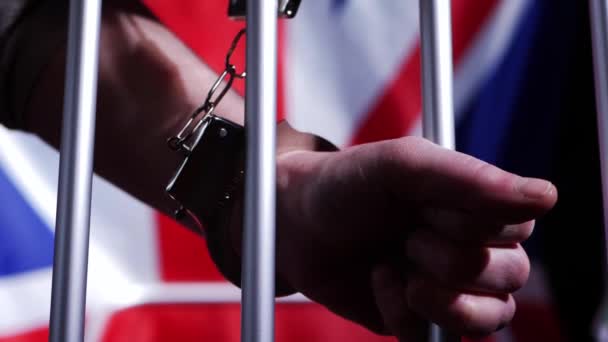 Fånge i handbojor genom fängelsebarer — Stockvideo