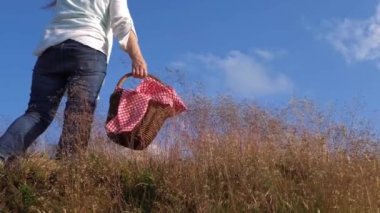 Piknik sepeti olan kadın, mavi gökyüzünün tadını çıkarıyor.