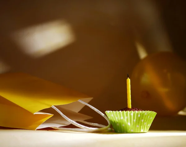 Bougie d'anniversaire jaune simple sur cupcake avec sac cadeau — Photo