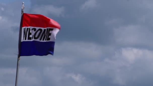 Καλώς ήρθατε χαιρετισμό σημαία που φέρουν στον άνεμο κατά των ουρανών — Αρχείο Βίντεο