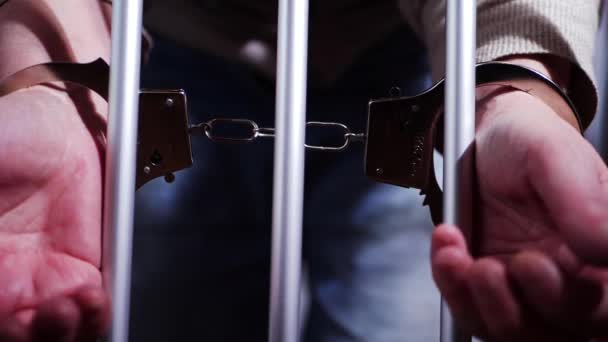 Vězeň v poutech přes mříže vězení — Stock video
