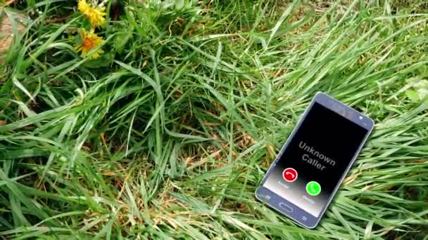 Cellphone left in the grass with incoming call from mysterious caller — 비디오