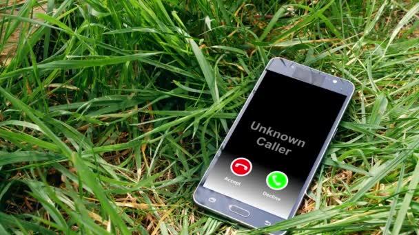 Mobilní telefon ponechán v trávě s neznámým příchozím voláním upozornění — Stock video