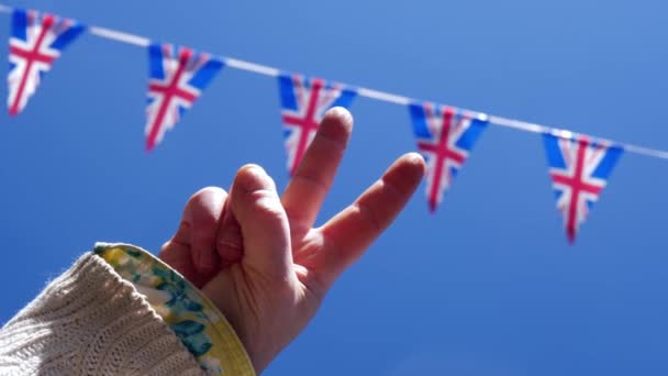 Victory salute against Union Jack British flag bunting — Stock Video