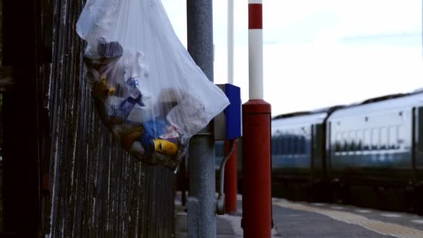 Bolsa de basura en la plataforma ferroviaria mientras pasa el tren — Vídeos de Stock