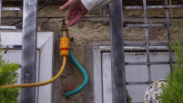 Home ownder ανοίγει βρύση βρύση βρύση στο εξωτερικό τοίχωμα του σπιτιού — Αρχείο Βίντεο