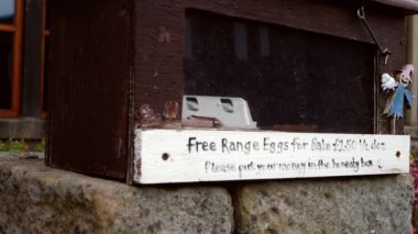 Free range eggs for sale outside country cottage medium shot slow motion selective focus
