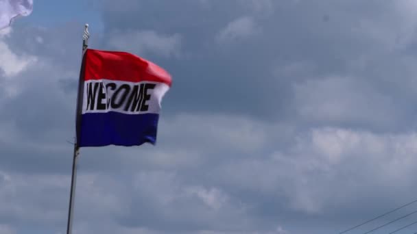 歓迎挨拶フラグ空に対して風の中で飛行スローモーションワイドショット選択的フォーカス — ストック動画