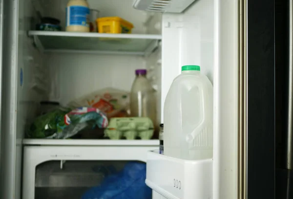 Bottle of milk in the refrigerator full of food wide shot selective focus