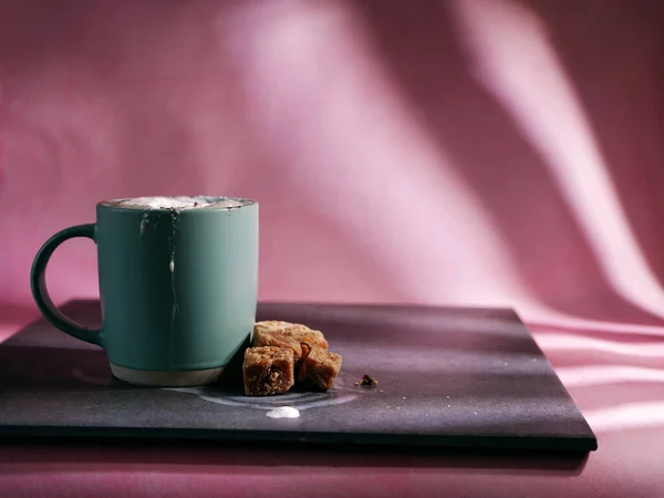 Hot chocolate drink and fudge on pink background medium shot selective focus