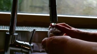 Lavaboda çalışan kadın giysisi. Yavaş çekim seçici odak noktası.