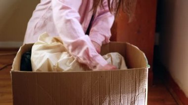 Kadın, yeni ev ortamında seçici odak noktasına taşınmak için kutudaki nesneleri arıyor