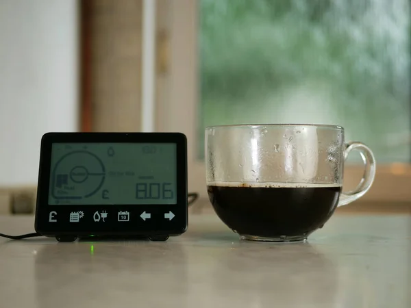 Home smart meter with cup of coffee on kitchen counter medium shot selective focus