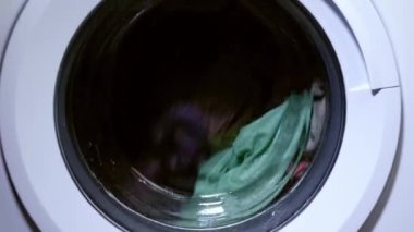 Çamaşır makinesinde dönen giysiler seçici odak noktasına odaklanıyor.
