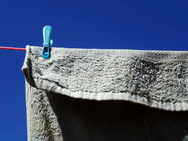 Towel hung on the washing line against blue sky medium shot selective focus