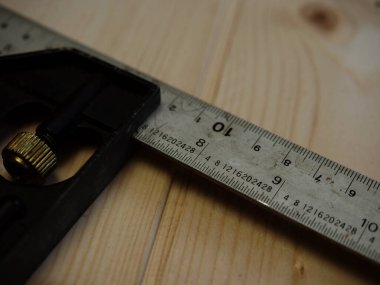 Carpenter tools square measure on wooden background close up shot selective focus