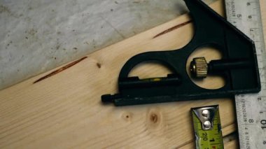Carpenter tools square and tape measure overhead panning 4k shot close up selective focus