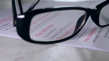 Pension statement through view of glasses close up dolly shot selective focus
