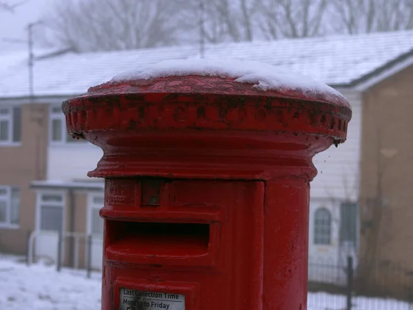 Red mail box in Britain covered in snow medium shot selective focus