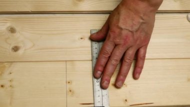 Carpenter using square to measure on wooden background overhead zoom shot selective focus