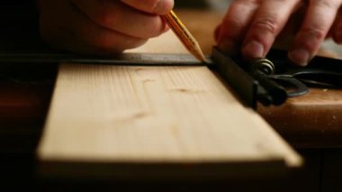 Carpenter using square to measure on wooden background close up 4k shot selective focus