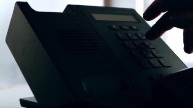 Making a call on office phone medium shot zoom out slow motion selective focus