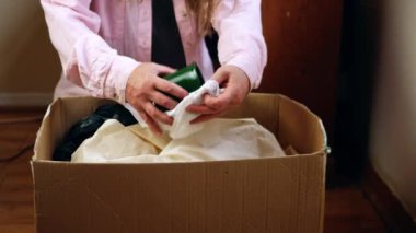 Packing items in a box for move to new home medium 4k shot selective focus