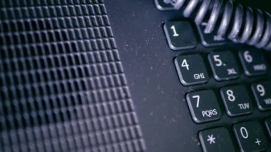 Office desk phone dial pad and coil close up shot hand held 4k shot selective focus