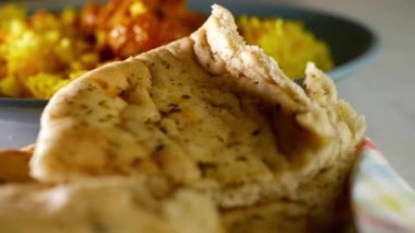 Chicken Korma curry with Pilau rice and naan bread overhead close up 4k zoom shot slow motion selective focus