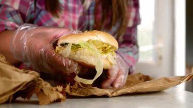 Caterer puts salad sandwich in paper bag medium slow motion 4k shot selective focus