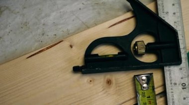 Carpenter tools square and tape measure overhead panning 4k shot close up selective focus