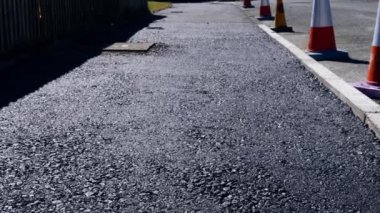 Fresh asphalt tarmac on path with traffic cones wide dolly shot selective focus
