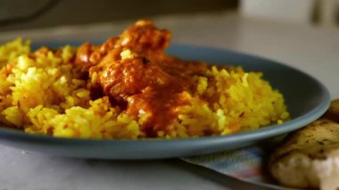 Chicken Korma curry with Pilau rice overhead medium 4k shot slow motion selective focus