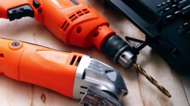 Electric power drill and sander on wooden background medium dolly shot selective focus