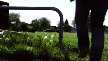 Woman walks through urban park slow motion medium zoom low shot selective focus