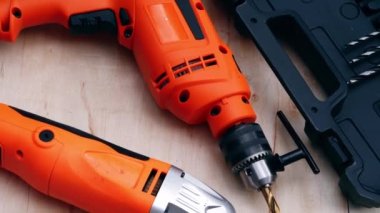 Electric power drill and sander on wooden background medium dolly shot selective focus
