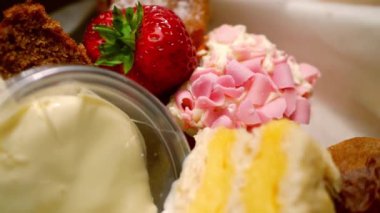 Selection of cakes and sweets for afternoon tea close up 4k selective focus