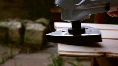 Using a power multi tool to sand wood 4k shot close up selective focus