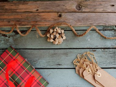 Christmas background with gift bag and tags on distressed wood background medium overhead selective focus
